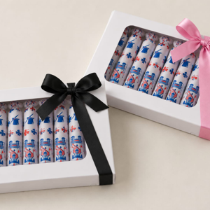 Two white gift boxes of habanitos in patterned wrappers, one tied with a black ribbon and one with a pink ribbon