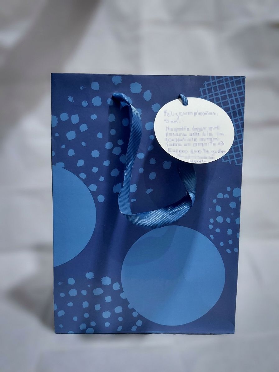A blue gift bag with a ribbon and a handwritten birthday card, delivered in Lima